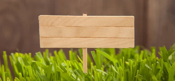 芝生の上の木製の板の小さな看板 — ストック写真