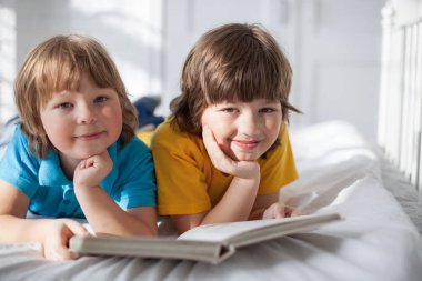 İki çocuk içeride kitap okuyor.