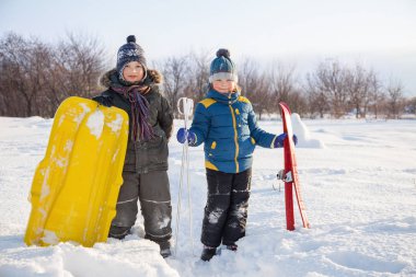 Kızak ve kayaklar kış açık havada iki mutlu çocuk