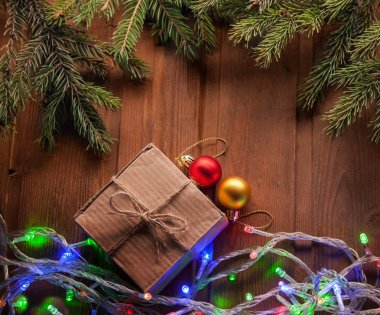 ahşap masa üzerinde Noel hediye kutusu ve garland üstten görünüm