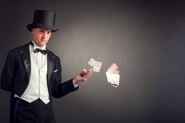 magician holding playing cards, showing focus, juggles clipart