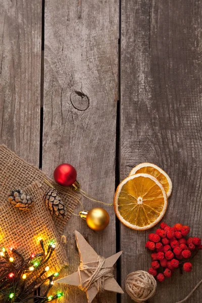 en iyi görünümünü Noel baubles, ahşap arka plan üzerinde kurutulmuş portakal ve parlak garland