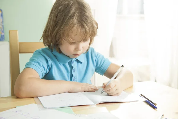 Kleine jongen doet zijn huiswerk voor basisschool — Stockfoto