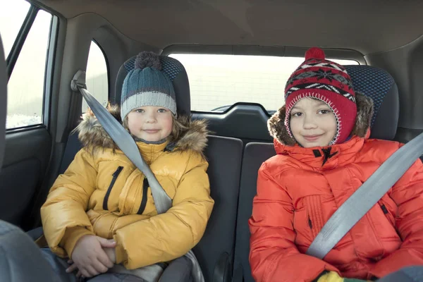 Arka koltuktaki arabada mutlu çocuklar kış gezisinde. — Stok fotoğraf