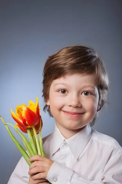 Vidám gyerek egy-egy csokor tulipán — Stock Fotó