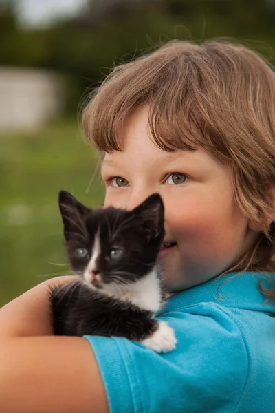 Poesje op arm van de jongen buitenshuis, kind enorme zijn liefde huisdier — Stockfoto