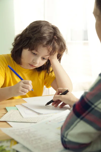 Mama helpt mijn zoon om moeilijk huiswerk te doen, Onschooling. Jongen dwangbevel — Stockfoto