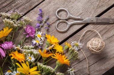 Eski grunge ahşap arka planda (chamo) yabani çiçekler ve makas