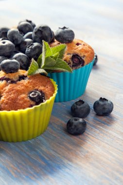 Muffin ahşap bir masa üzerinde yaban mersini ile. taze meyveleri ve swe