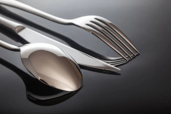 Knife and fork, spoon, on a black background — Stock Photo, Image