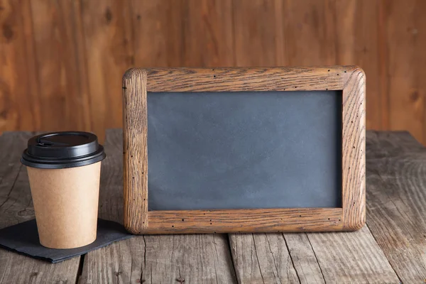 Coffee paper cup with vintage slate chalk board, on grunge wood — Stock Photo, Image