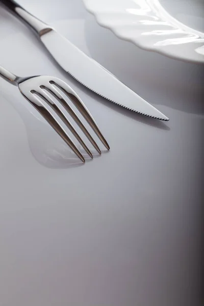 Prázdný talíř s nožem a vidličkou na bílém pozadí — Stock fotografie
