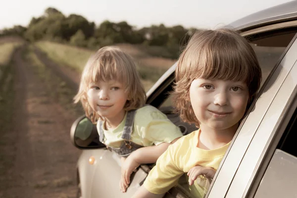 Duas crianças alegres sentadas no carro — Fotografia de Stock