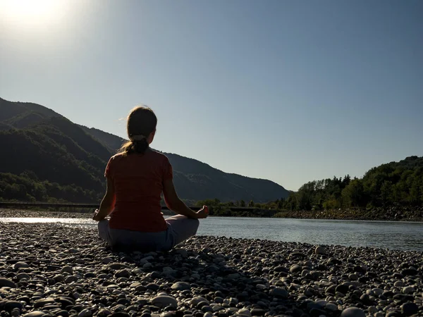 Junge Frau praktiziert Yoga in Lotus-Pose am Bergsee — Stockfoto
