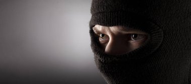 Karanlık bir arka planda kar maskeli kızgın bir adam..