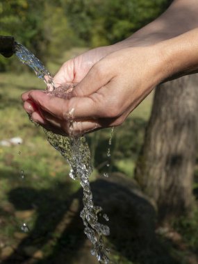 Kadın eli, arka plandan su döker.