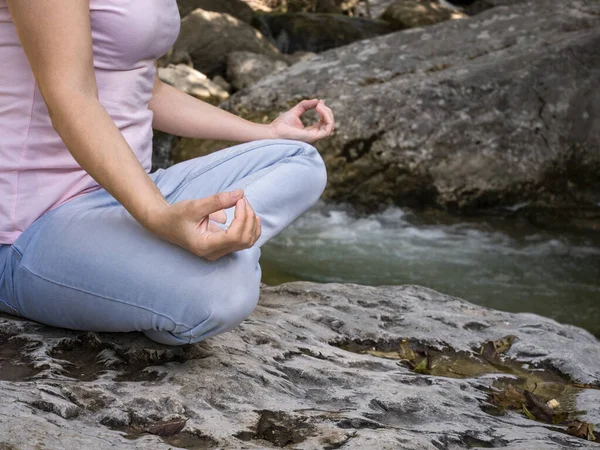 Mulher está praticando ioga em pose de lótus no lago da montanha — Fotografia de Stock