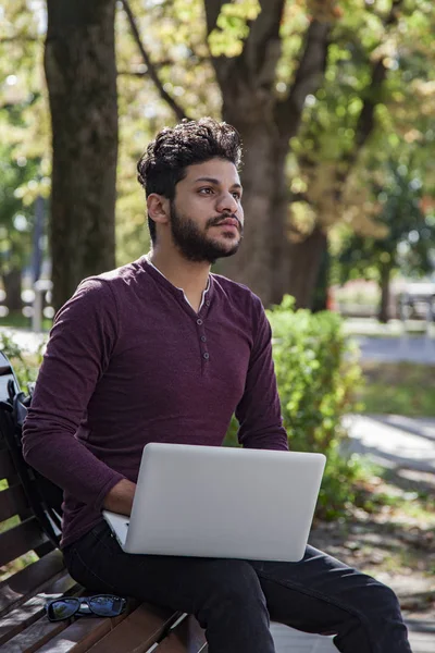 El hombre con el portátil en el parque de verano en día brillante — Foto de Stock