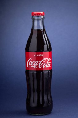 Belgorod, Rusya - 28 Mayıs 2020: Mavi Arkaplan 'da klasik Coca-Cola şişesi. Coca-Cola tarafından üretilen karbonatlı meşrubat.