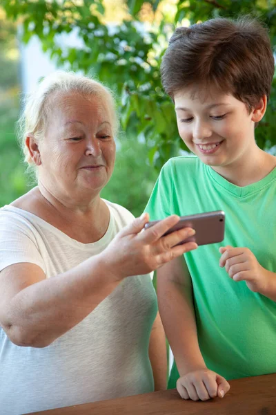 Netter Junge Mit Smartphone Bei Oma Auf Der Heimischen Veranda — Stockfoto