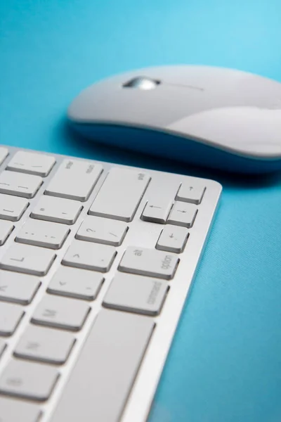 青いテーブルの上の白いキーボードとマウス — ストック写真
