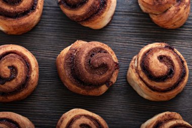 Taze pişmiş tarçınlı çörekler ve ahşap arka planda baharatlar. Noel pastaları. Yakın plan. Üst görünüm.