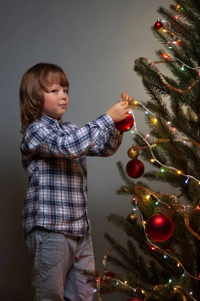 クリスマスツリーを飾る幸せな少年の肖像画 鍵が低い — ストック写真