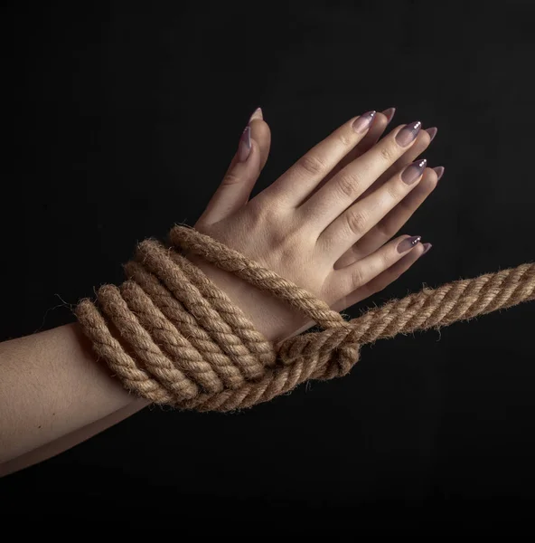 Mulher Mãos Amarradas Com Uma Corda Grossa Close Fundo Preto — Fotografia de Stock