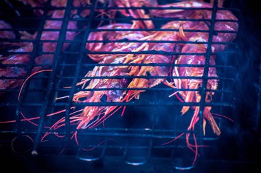 Karides royal, ızgara. Karides üzerinde sıcak bir mangal dumanı tüten apetisant. Bir siyah ızgara karides kavrulmuş.