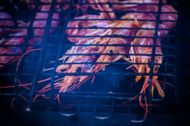 Karides royal, ızgara. Karides üzerinde sıcak bir mangal dumanı tüten apetisant. Bir siyah ızgara karides kavrulmuş.