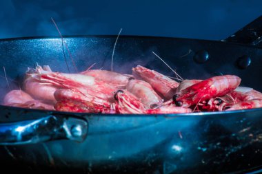 Karides appetizingly bir tavada ayçiçek yağı ile yanmış. Açık ki onlardan orada nasıl bir ışık duman. İştah açıcı yemek. Deniz ürünleri. Gıda yakın çekim.