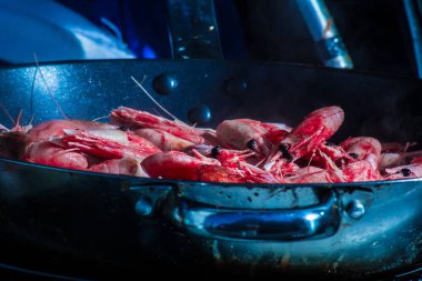 Karides appetizingly bir tavada ayçiçek yağı ile yanmış. Açık ki onlardan orada nasıl bir ışık duman. İştah açıcı yemek. Deniz ürünleri. Gıda yakın çekim.