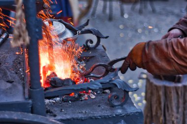 Demirci nal küçük forge fırın üzerinde çalışıyor. Moskova'da Rusya Fuarı'nda dövme at nalı.