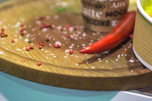 Red pepper and spilled seasonings on the background of wooden boards.