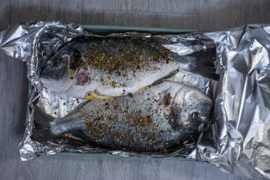 Dorado taze baharat bir pişirme çanağı ve folyo ile fırında pişmiş.
