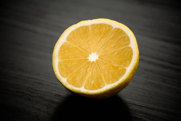 Limón Amarillo Recién Cortado Por Mitad Contra Una Mesa Negra — Foto de Stock