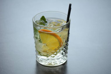 Buzlu bir bardak limonata ve tahta bir da limon bir dilim