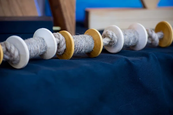Les bobines en bois de fil ou de corde reposent sur un tissu sombre. Fait main. Couture en fablab . — Photo