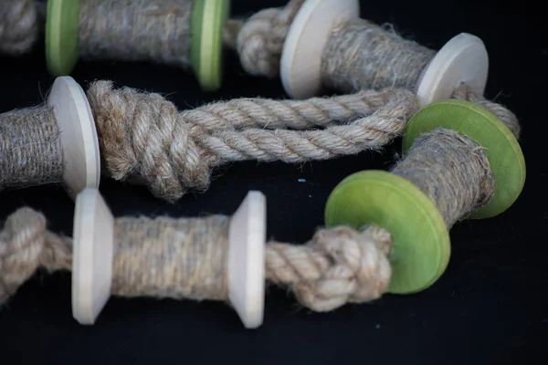 Les bobines en bois de fil ou de corde reposent sur un tissu sombre. Fait main. Couture en fablab . — Photo