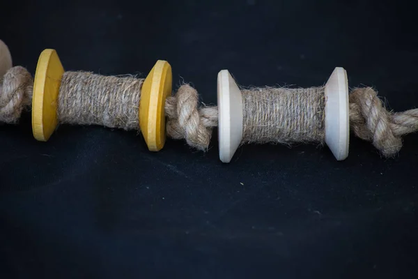 Wooden spools of thread or rope lie on a dark cloth. Handmade. Sewing in fablab. — 스톡 사진