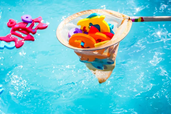 Educational water game for children. Fish in the form of letters of numbers and images of animals and a net for fishing. Fun for kids — Stock Photo, Image