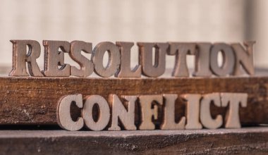 'RESOLUTION' and 'CONFLICT' text on wooden background. clipart