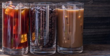 Ahşap arka plan üzerinde siyah kahve, süt kahve ve fasulye buzlu