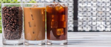 Ahşap arka plan üzerinde siyah kahve, soğuk latte ve fasulye buzlu