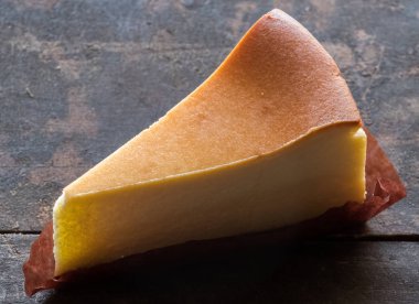 Ahşap masa üstüne peynir pasta bir dilim