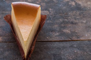 Ahşap masa üstüne peynir pasta bir dilim