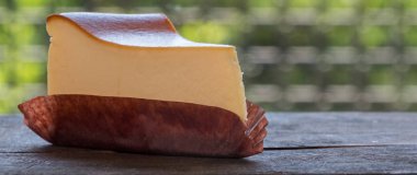 Ahşap masa üstüne peynir pasta bir dilim