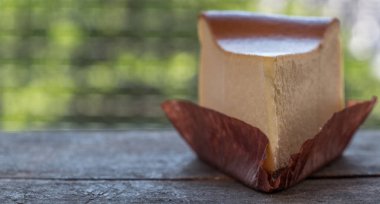 Ahşap masa üstüne peynir pasta bir dilim