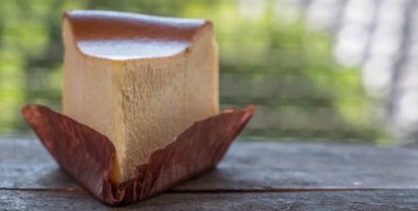 Ahşap masa üstüne peynir pasta bir dilim