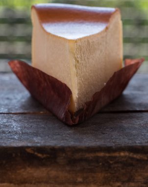 Ahşap masa üstüne peynir pasta bir dilim